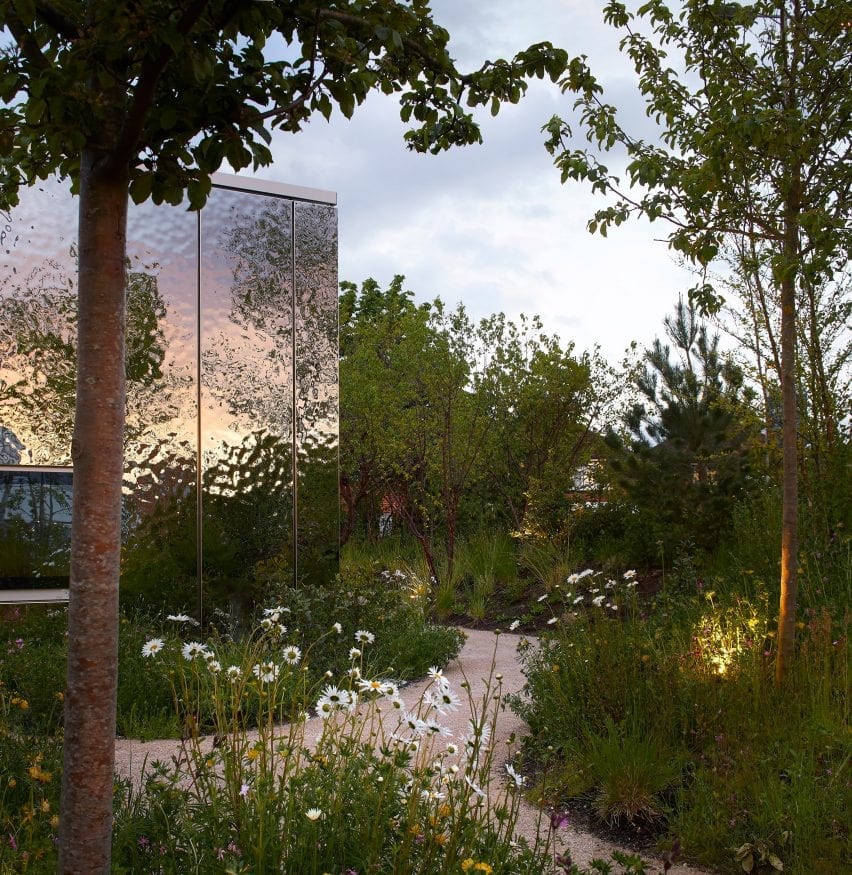 A mirrored pavilion surrounded by gardens