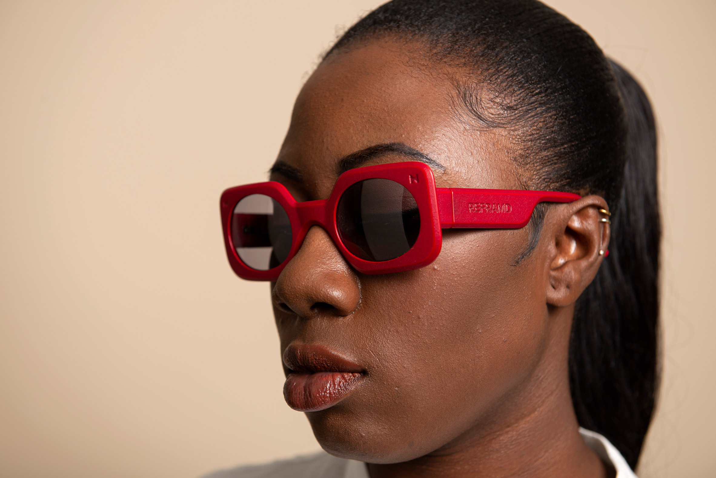 A woman wearing a red pair of sunglasses