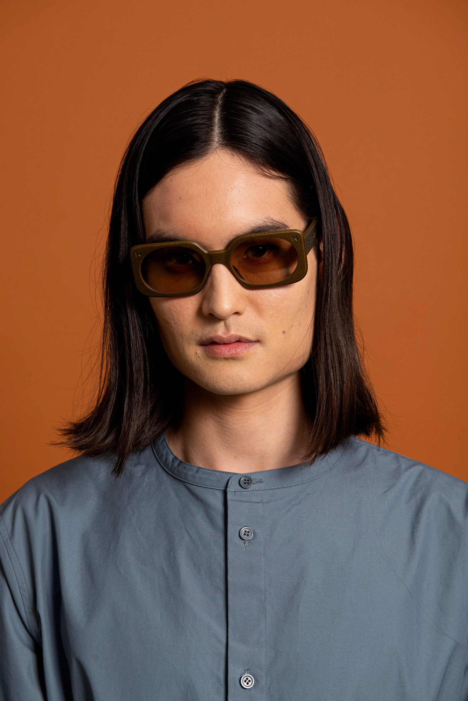 A man wearing rectangular-shaped brown sunglasses