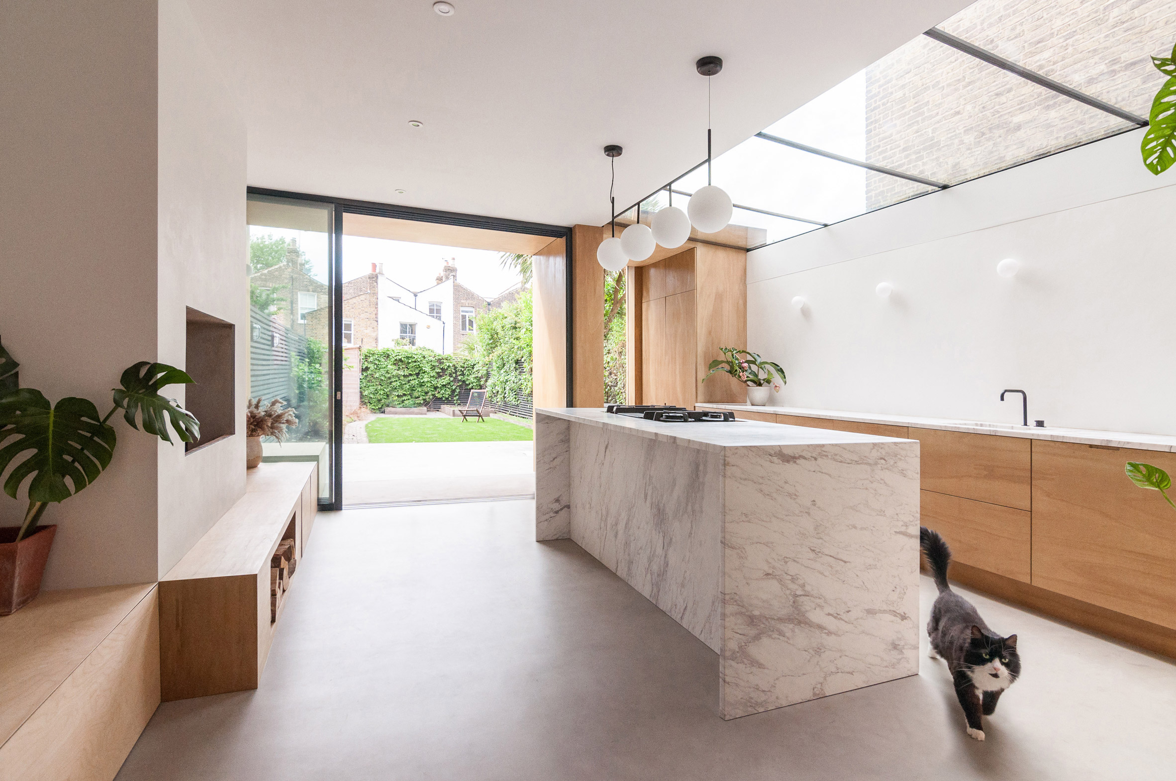A kitchen with a marble island and wooden cabinetry