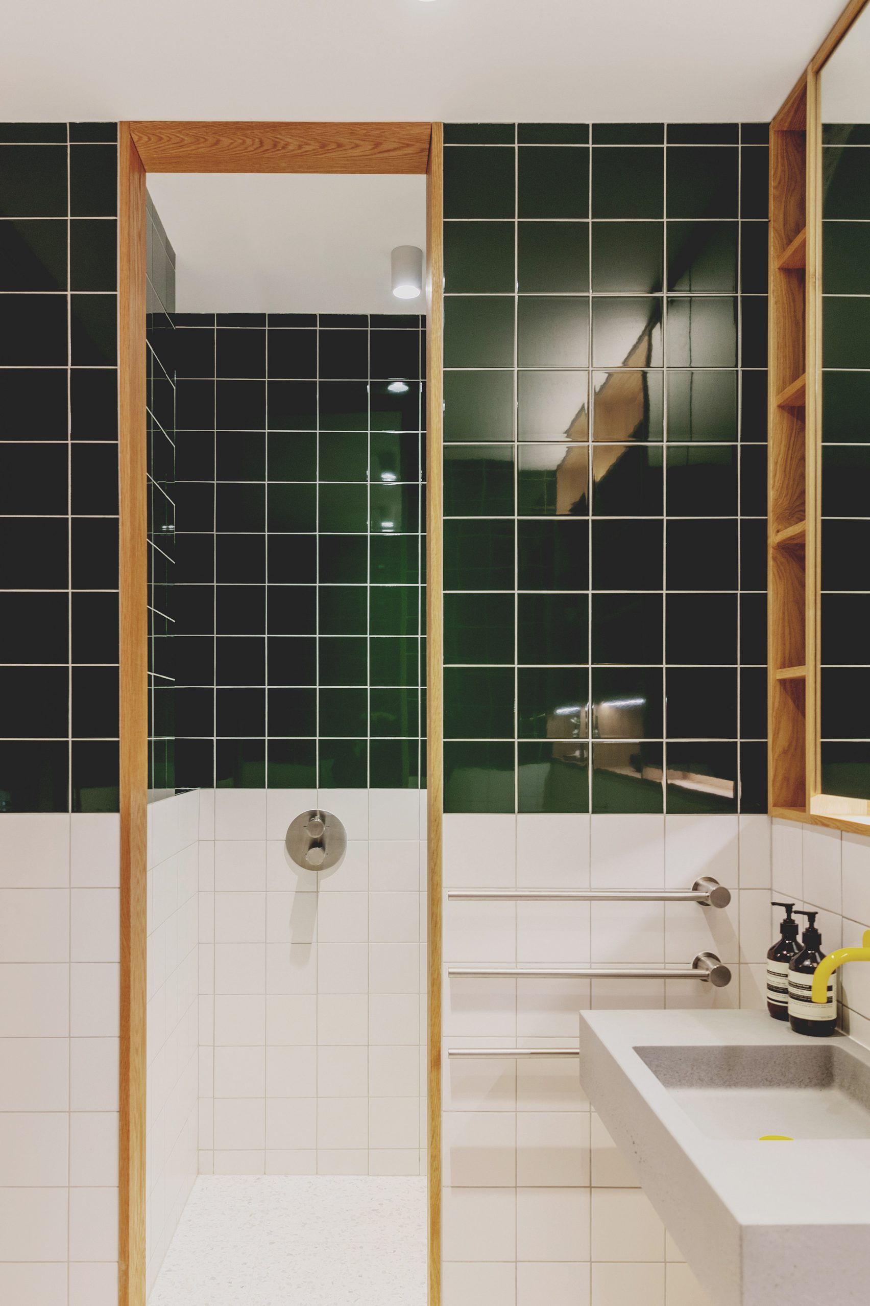 Bathroom with green and white tiles in St John Street warehouse apartment by Emil Eve Architects