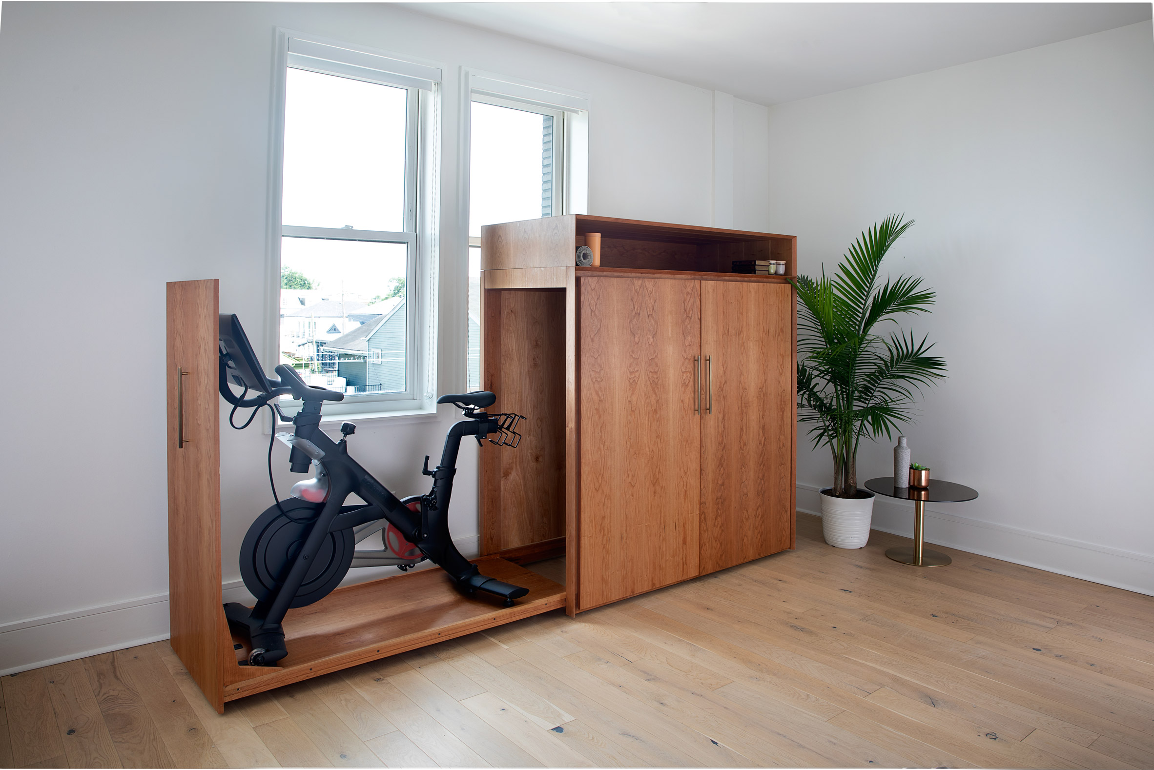 Mid-century cabinet with the full-height side drawer opened to reveal a stationary bike