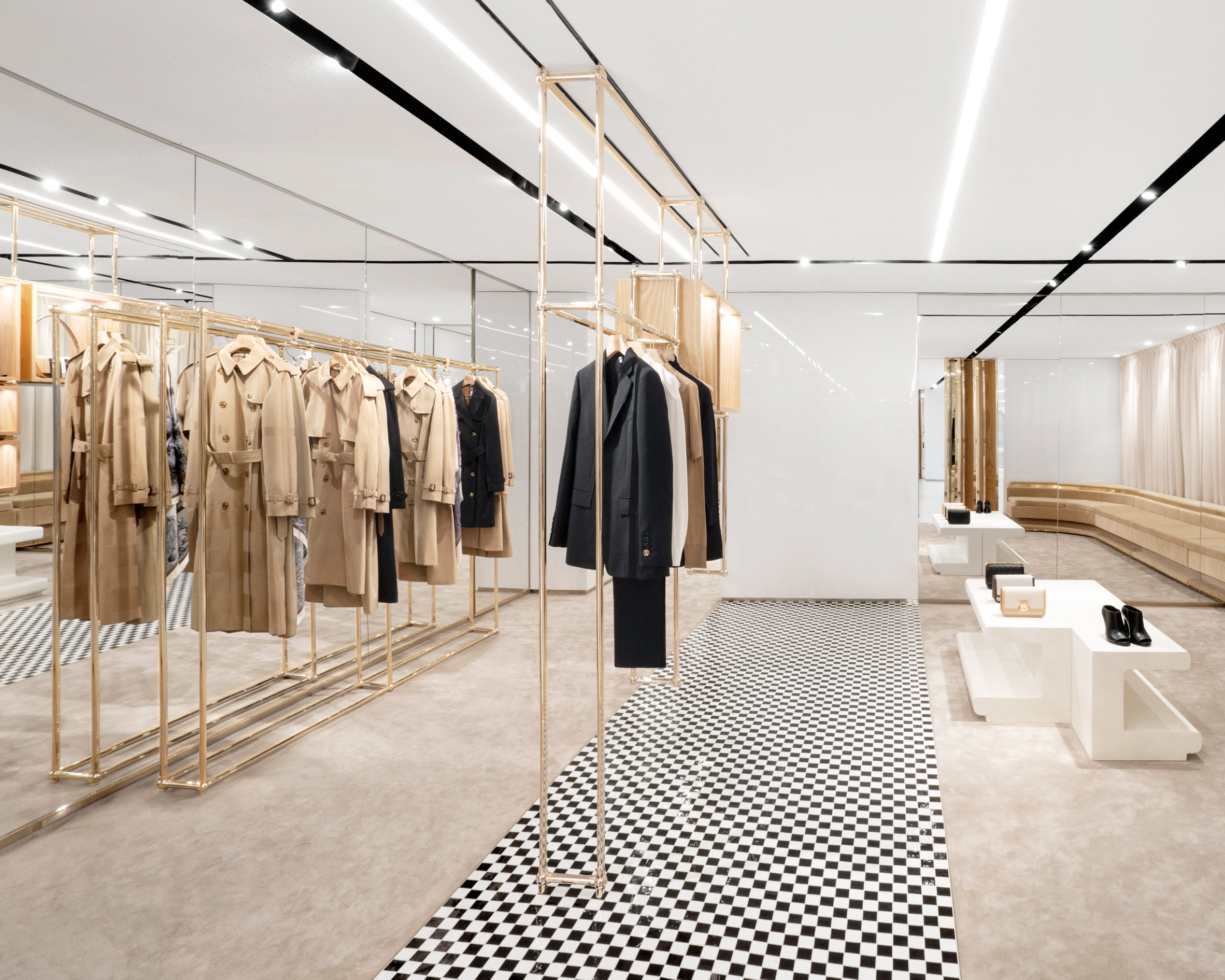 Trench coats on champagne-coloured steel shelves in No.1 Sloane Street shop by Vincenzo De Cotiis