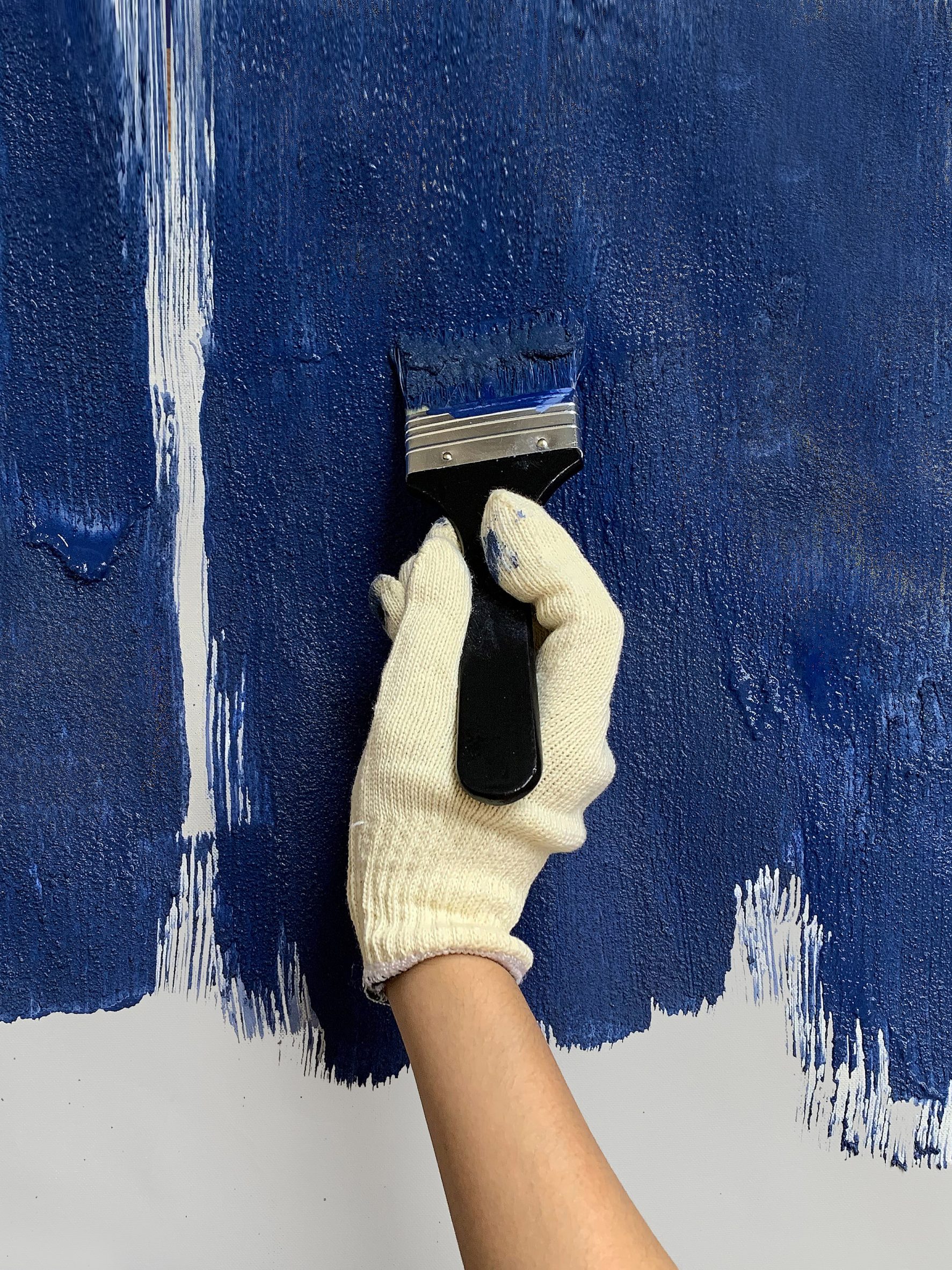 Hand applying blue Celour paint with a brush