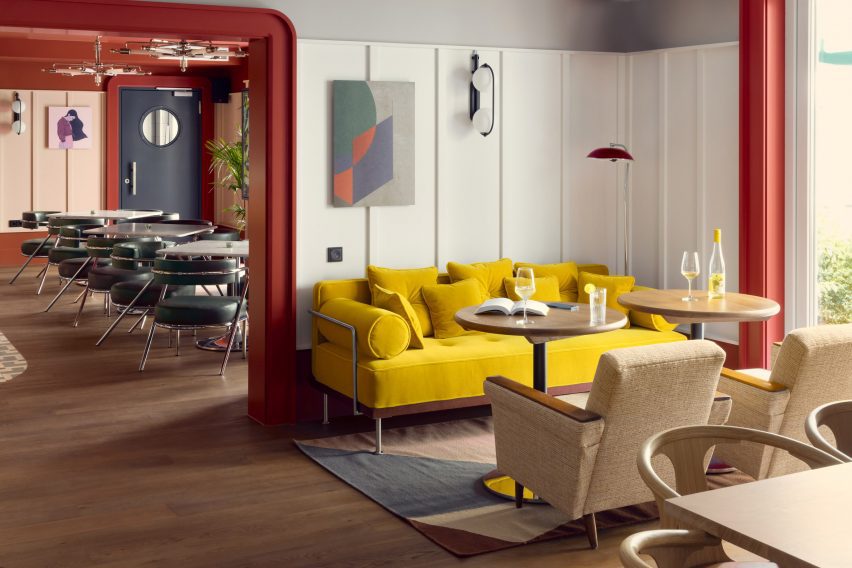Yellow sofa in hotel interior by Fettle against white wall panels