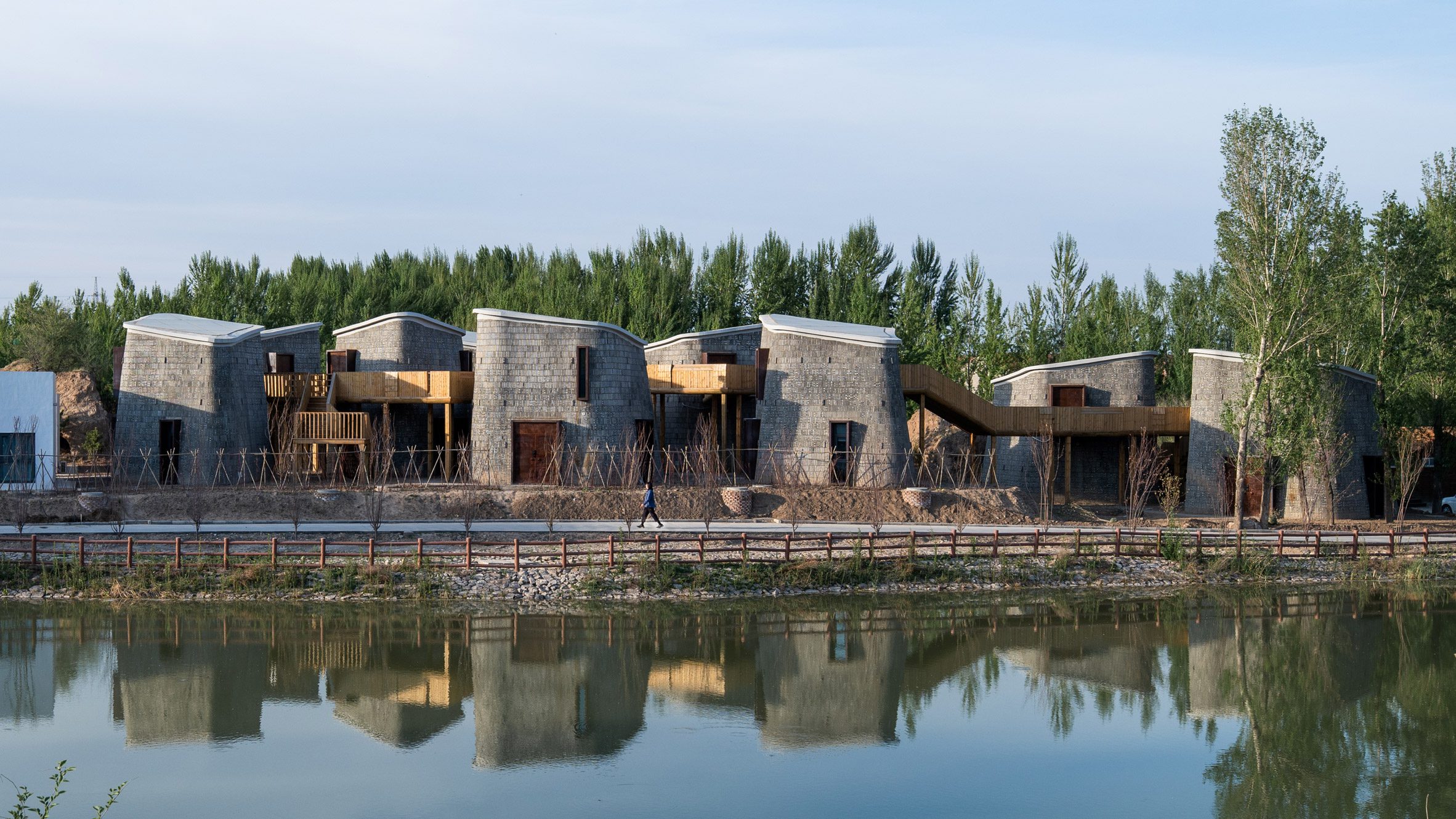 Brick-clad pods connected by wooden walkway in Grotto Retreat Xiyaotou