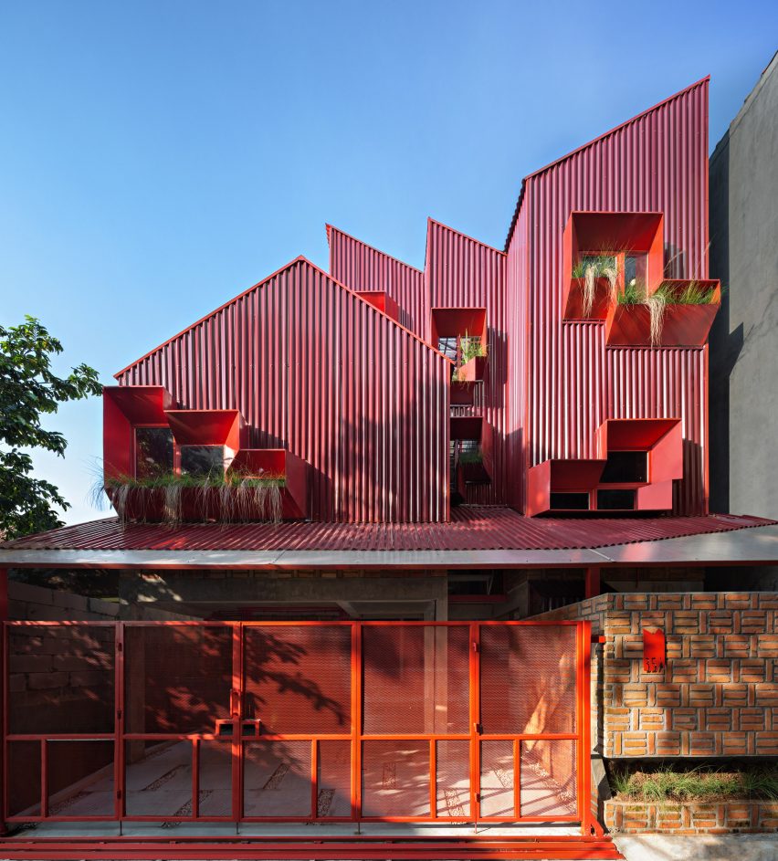Exterior of red boarding house with shape of stacked houses