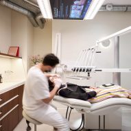 A dentist wearing white operating on a woman