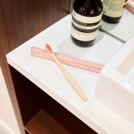 A pair of pink toothbrushes on a white sink