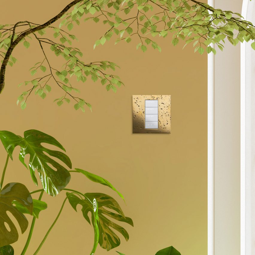 A lighting control in gold with plants around it