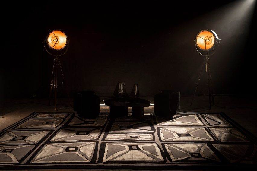 Tables, chairs and lights on a monochrome Meteorito rug