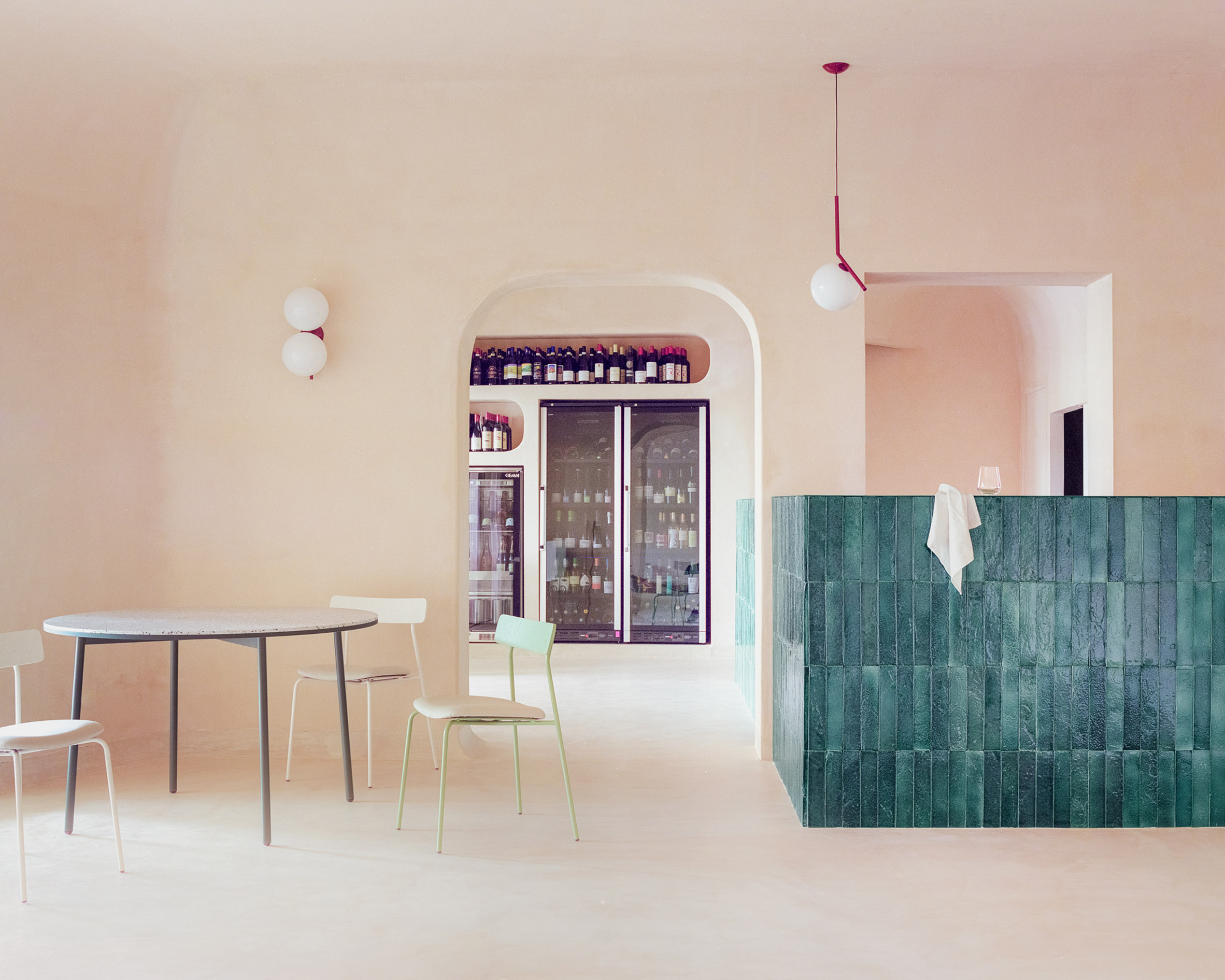 Green tiled counter next to seating area with views to wine fridge in Myrto pizzeria
