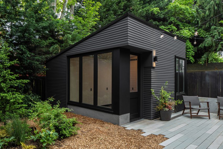 A black wooden shed in a garden in Seattle