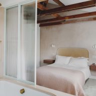 Studio Hagen Hall 1970s-style townhouse bedroom with a bathtub and glass screen