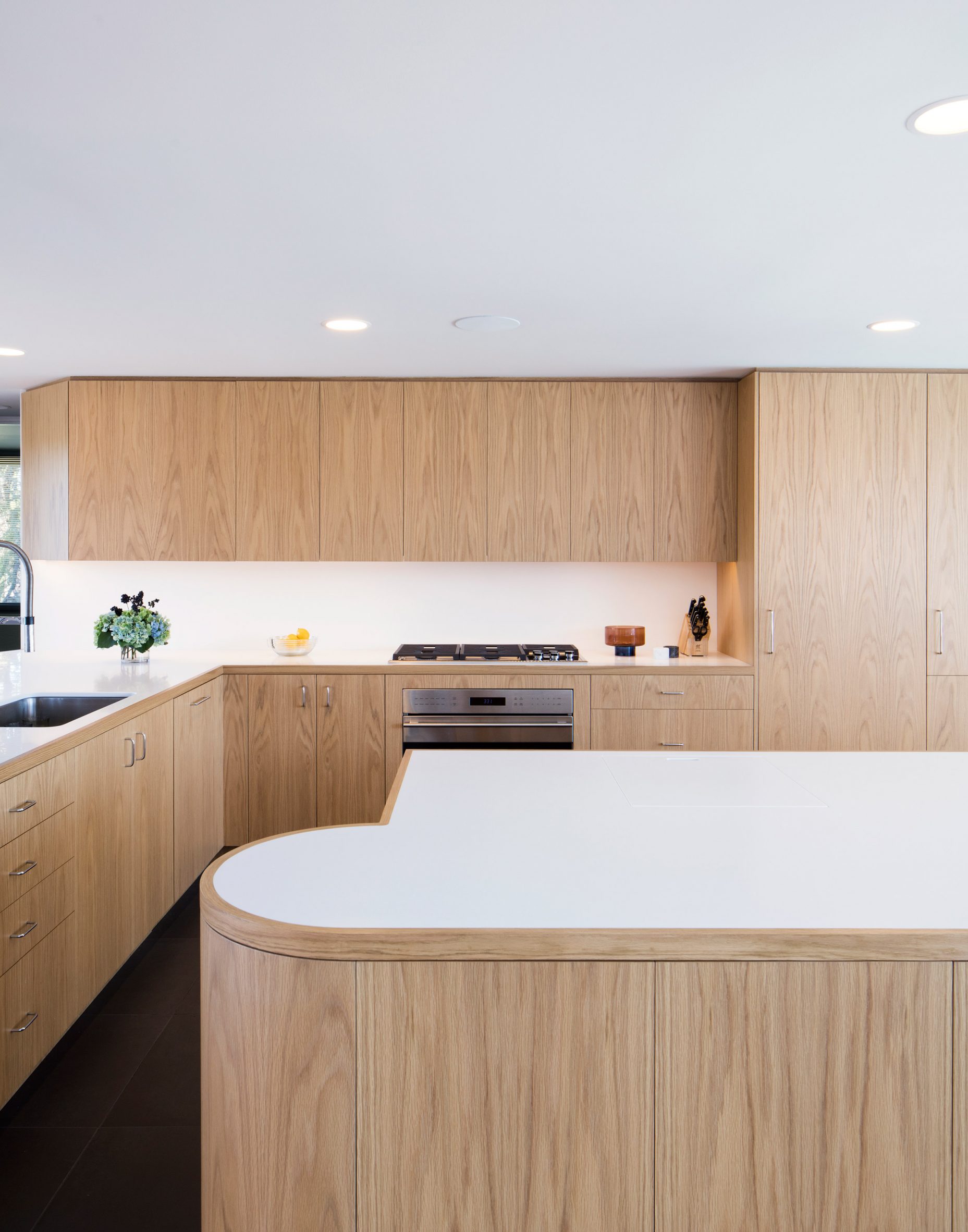 The kitchen boasts Corain countertops in a white hue