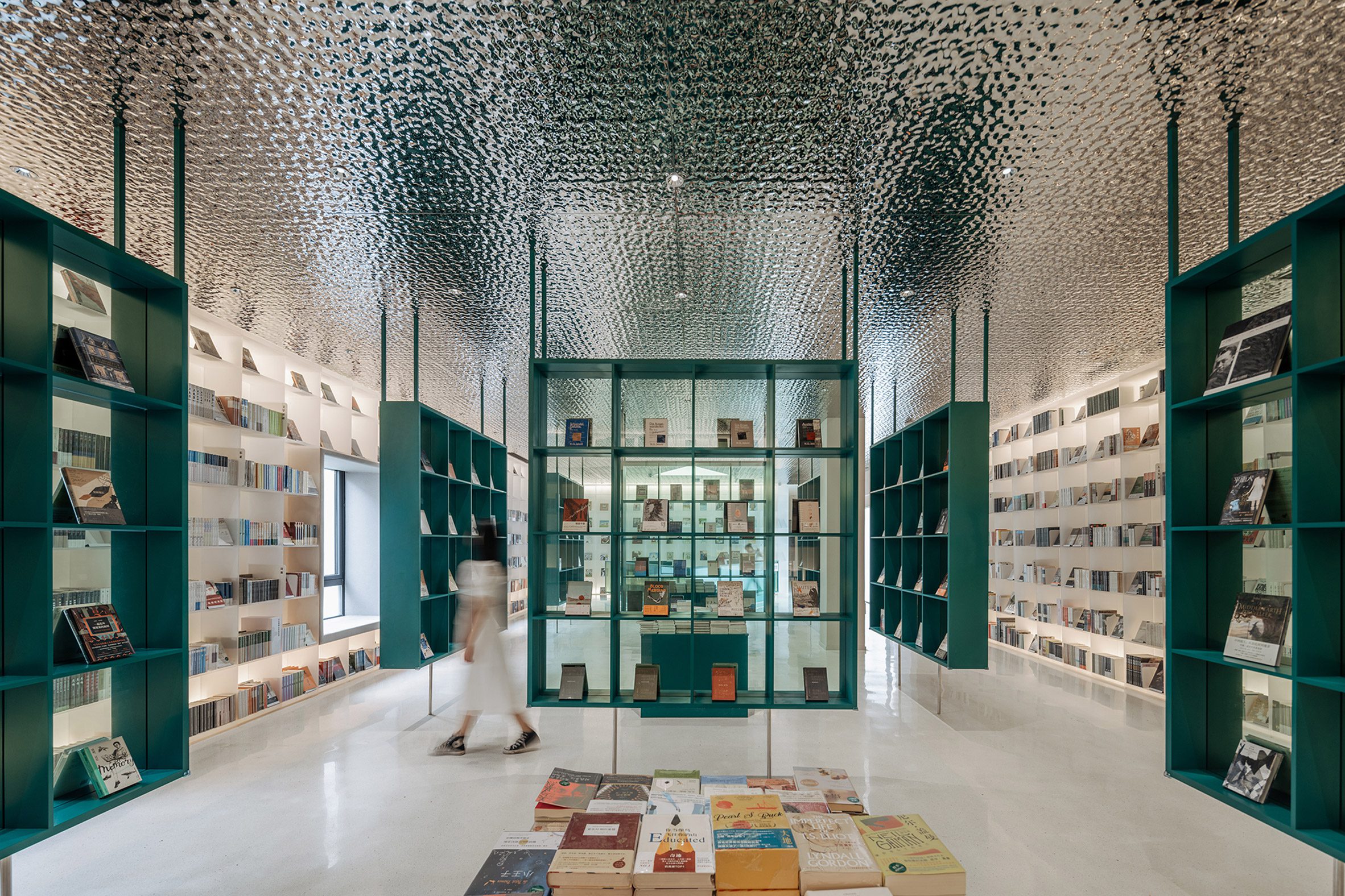 Bookshop by Wutopia Lab with petrol blue display stands and corrugated aluminium ceiling