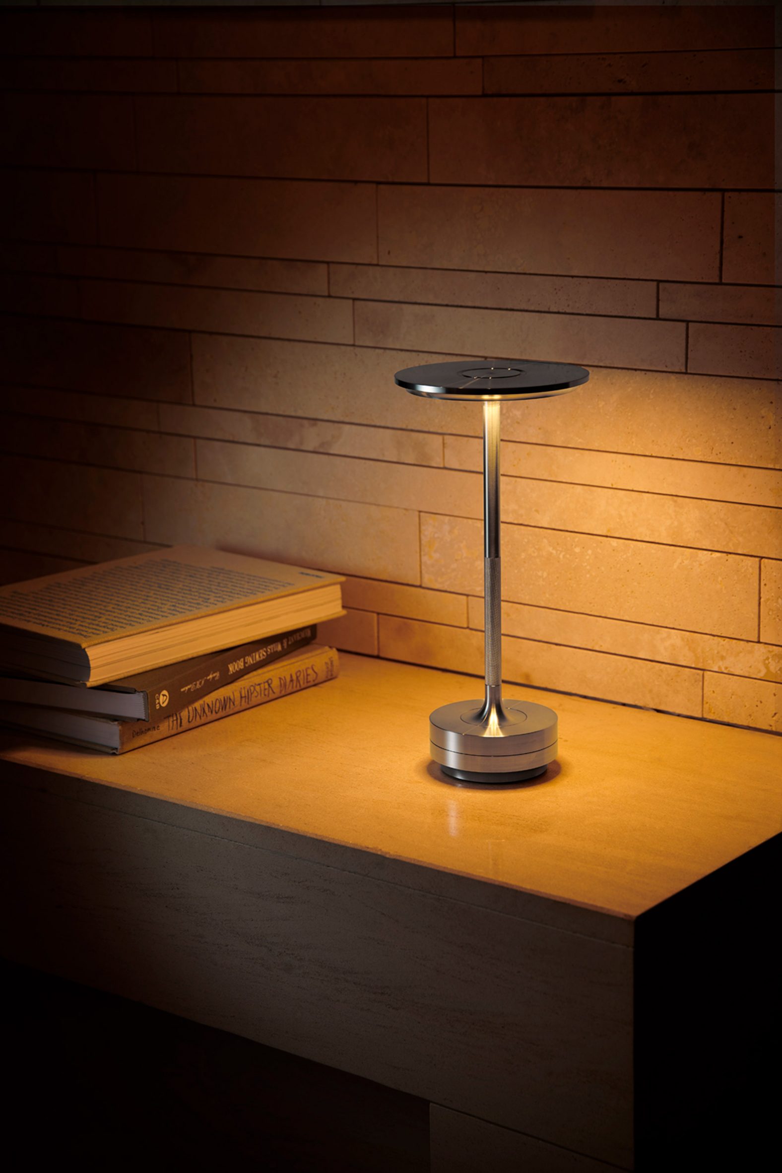 Turn portable lamp in aluminium on a desk with low lighting