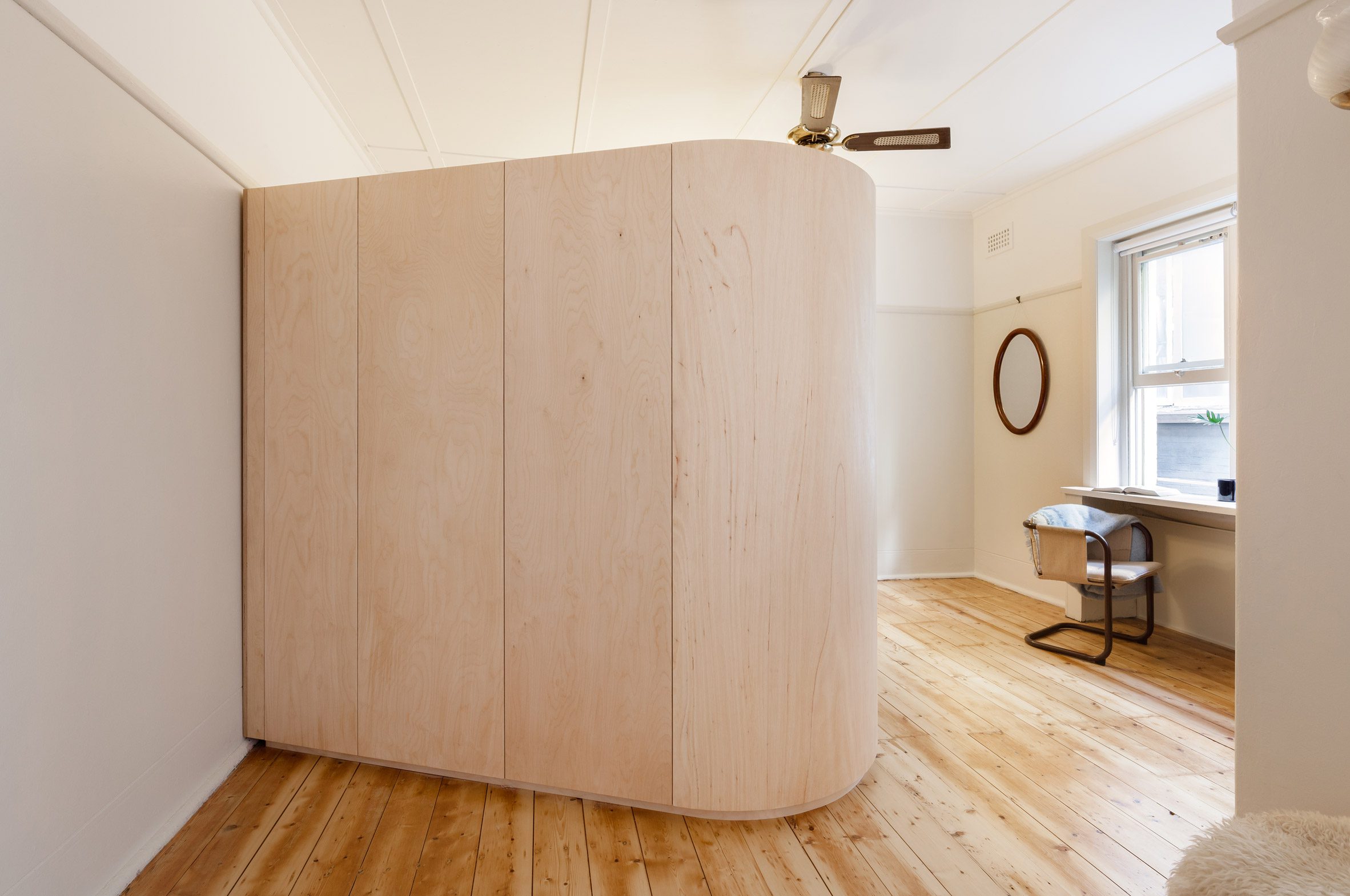 A plywood volume conceals a bed and storage