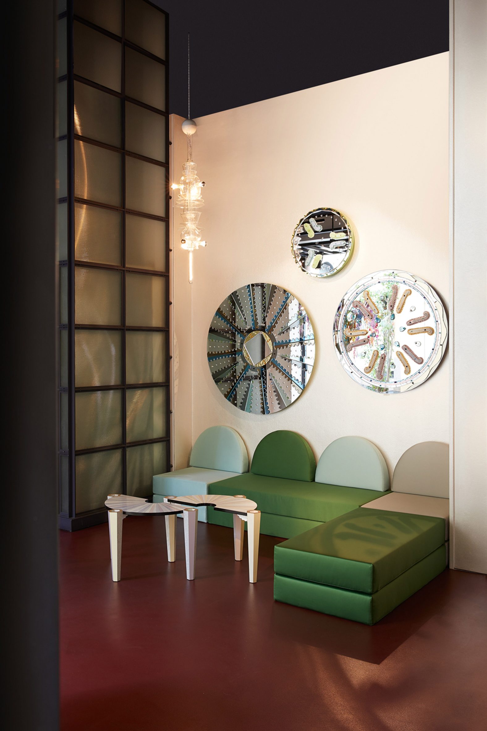 Green sofa under circular mirrors