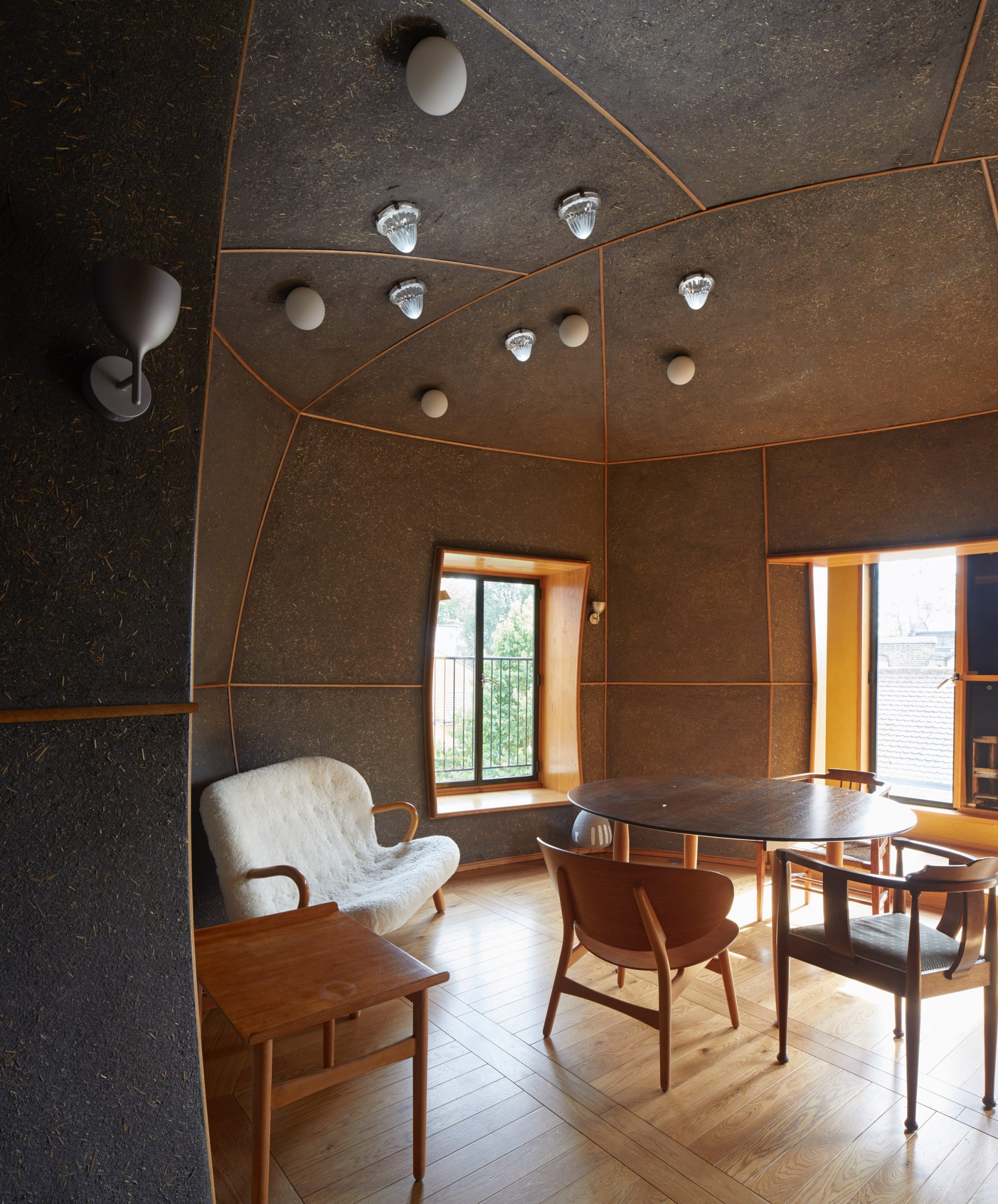 A table and chairs inside a room covered in Clayworks' Arakabe wall finish