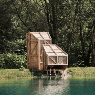 A wooden cabin perched over a lake