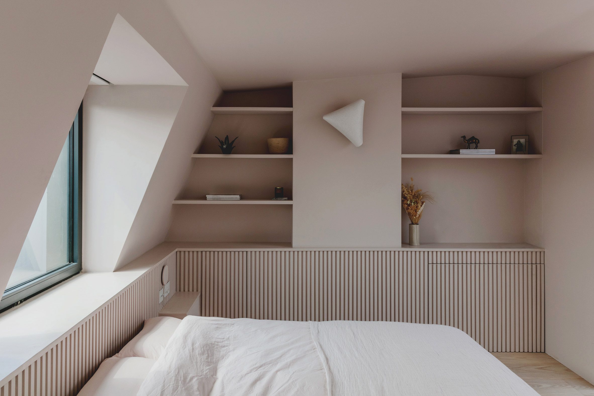 Bed and window in Narford Road loft extension by Emil Eve Architects