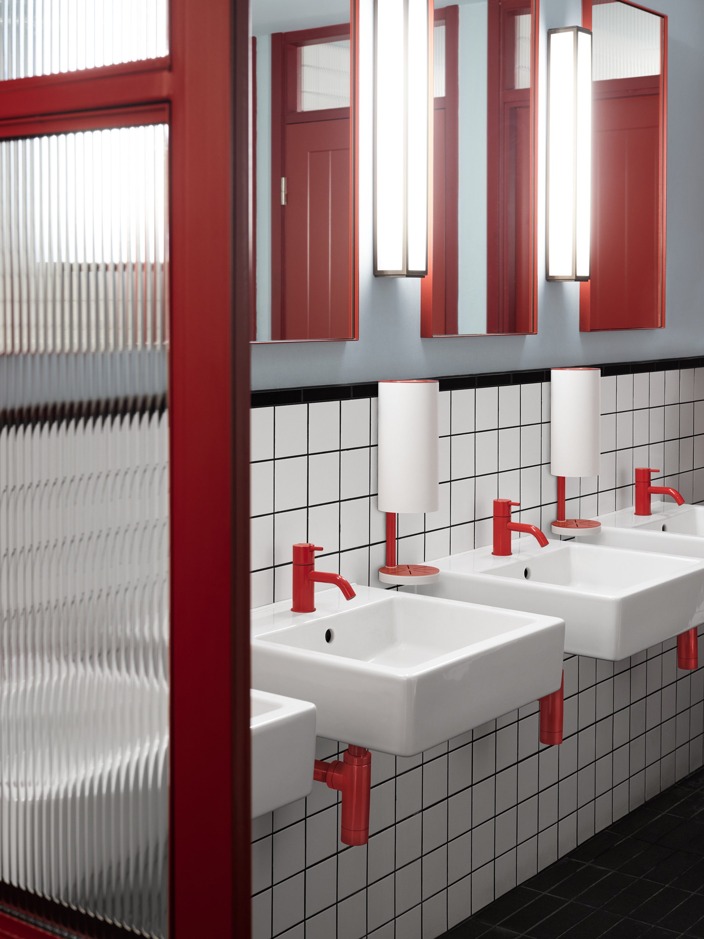 Red and white wall-mounted RS11 dispensers installed within a bathroom