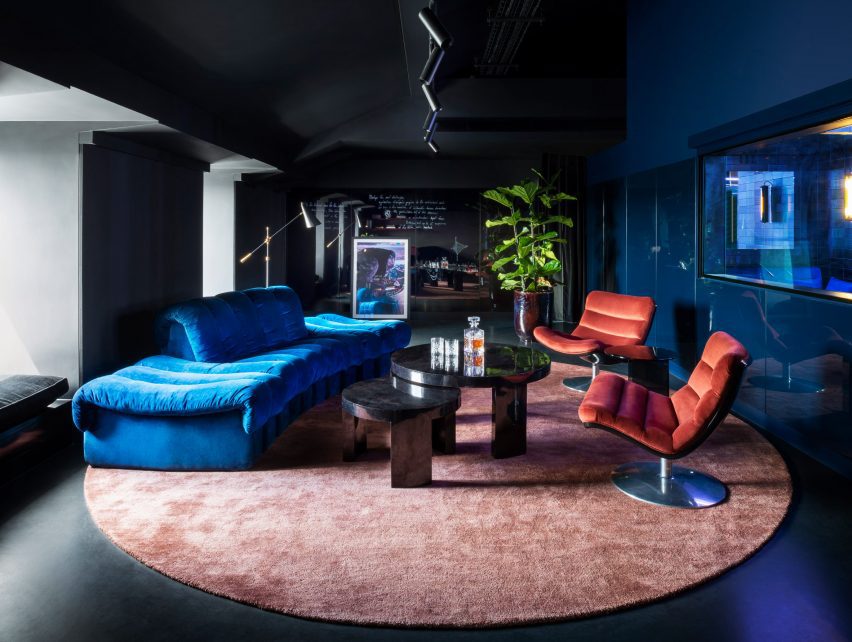 Blue and salmon furnishings pictured in a dark painted room