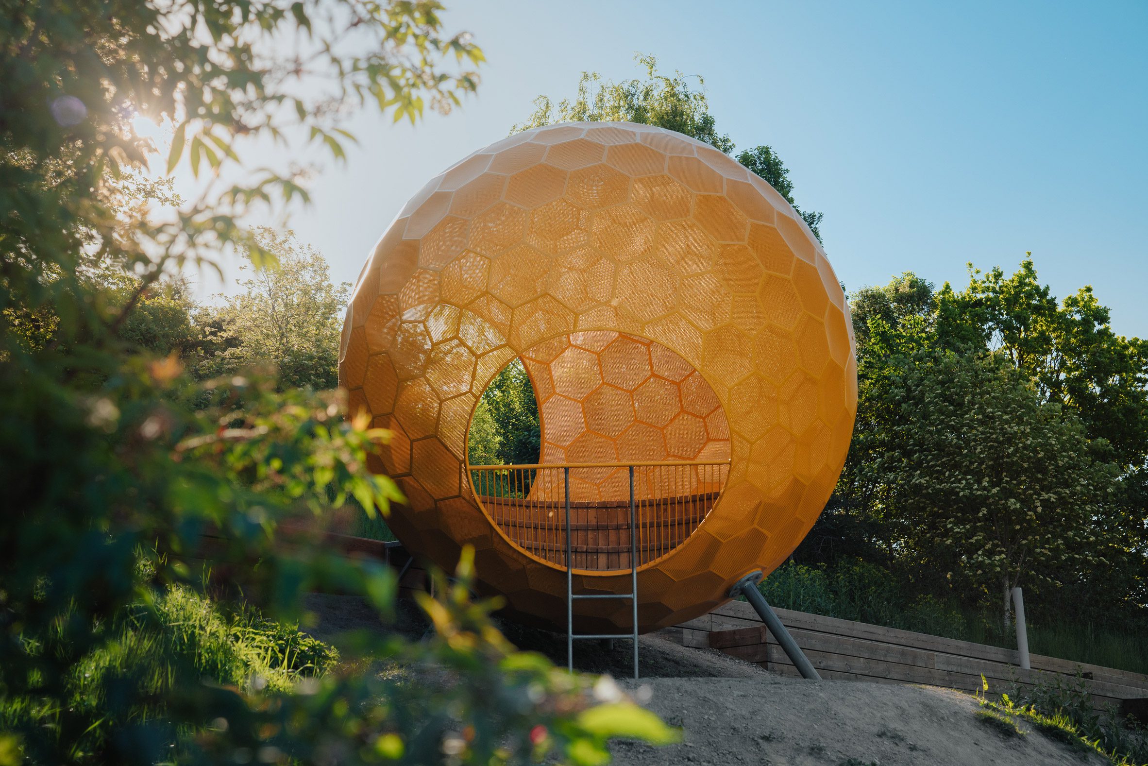 A hollow orange structure in Vårbergstoppen park