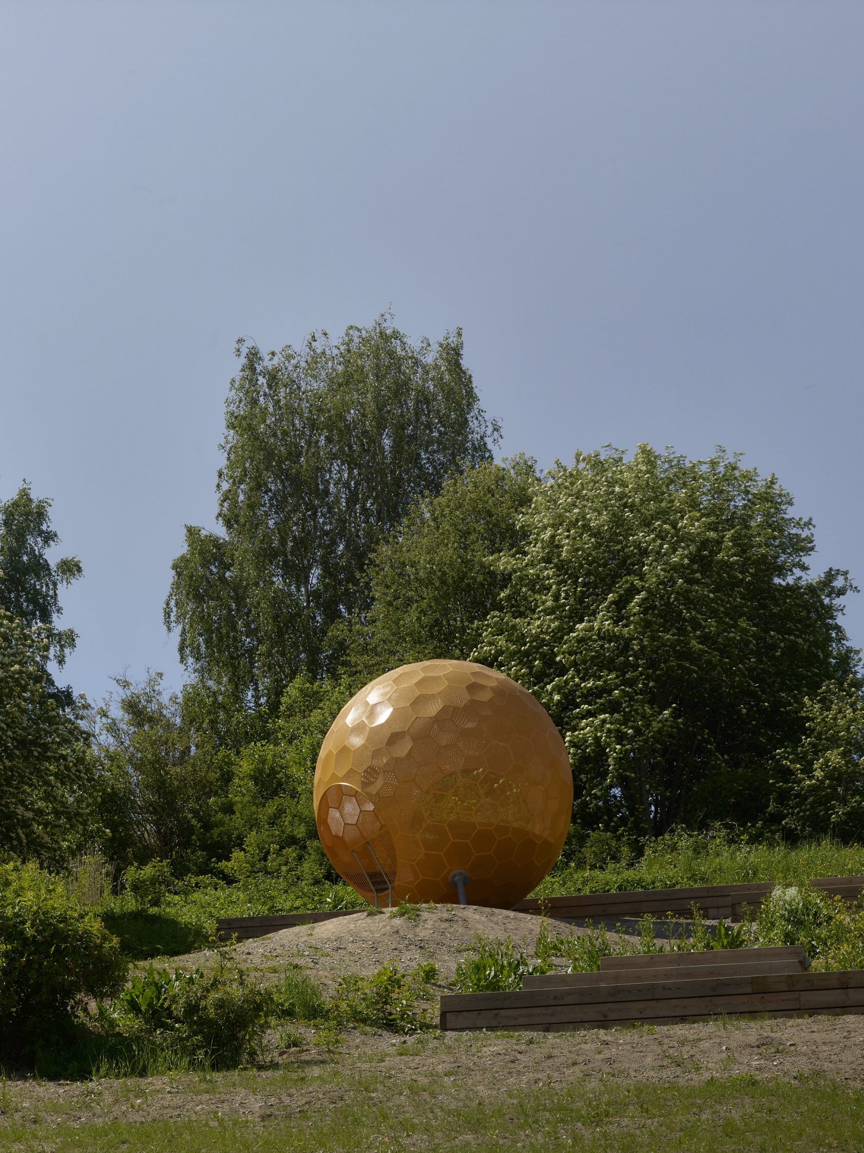 A perforated metal orange sphere at the top of the park