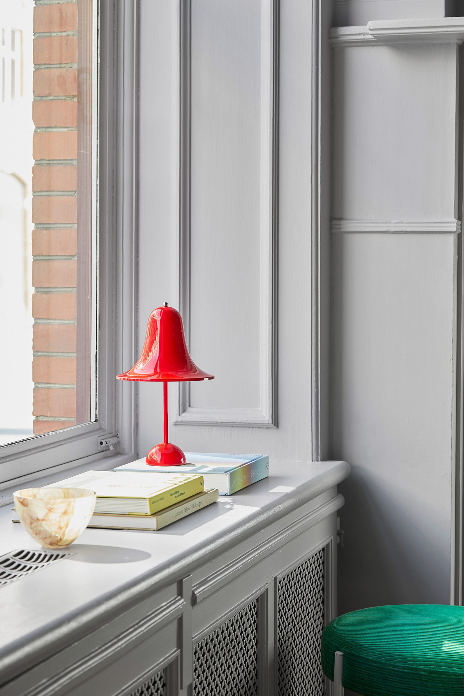A red Pantop Portable light on a windowsill