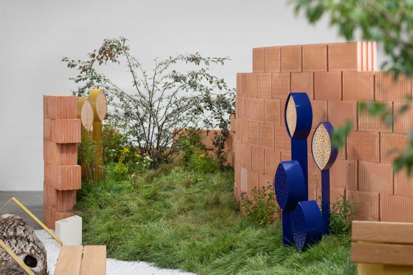 Red brick wall with insect hotels and artificial hill by Note Design Studio