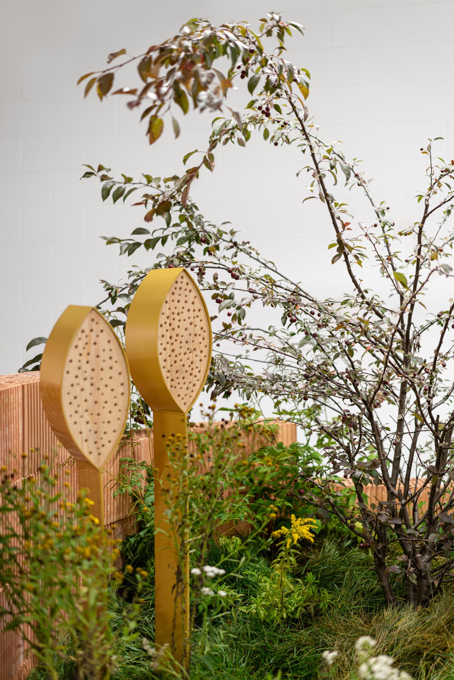 Insect hotel next to small tree in Habitats installation by Note Design Studio