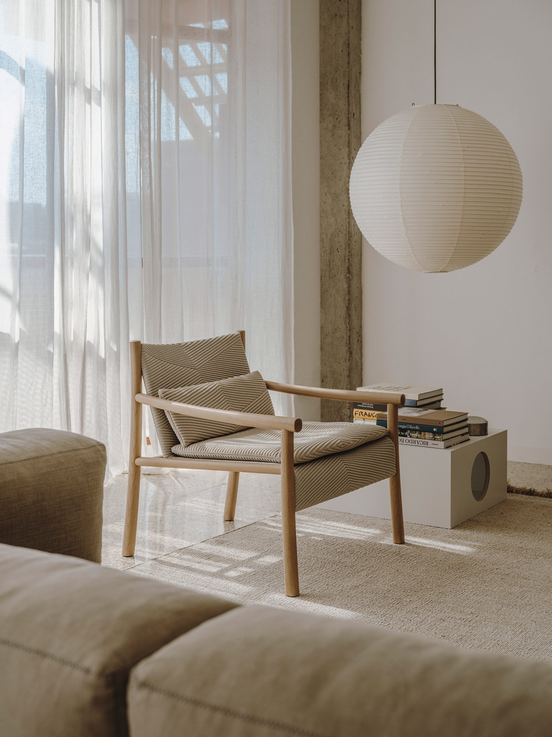 Kata chair with beige upholstery situated in a pared-back neutral interior