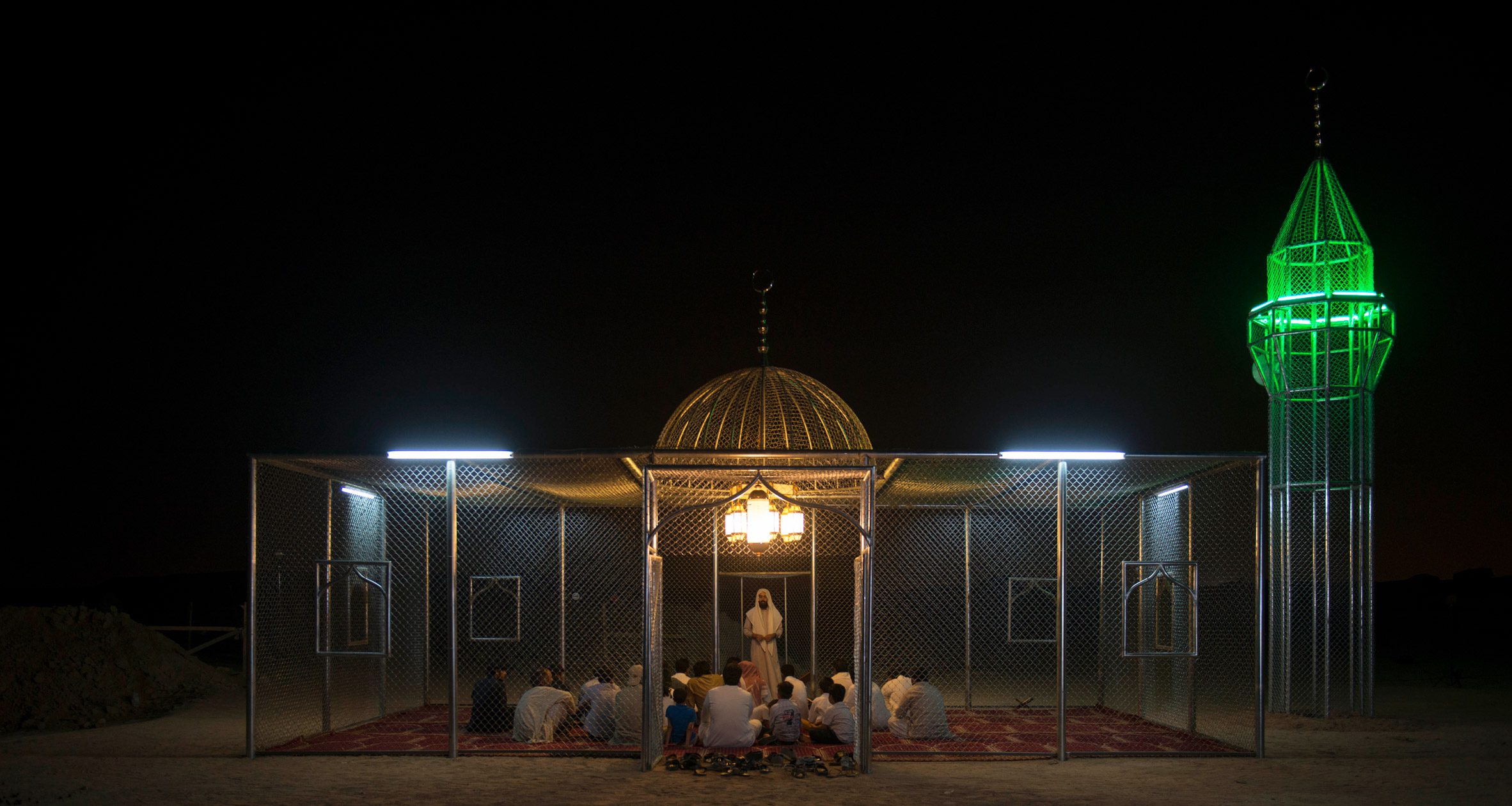 People gather inside the steel mosque at night