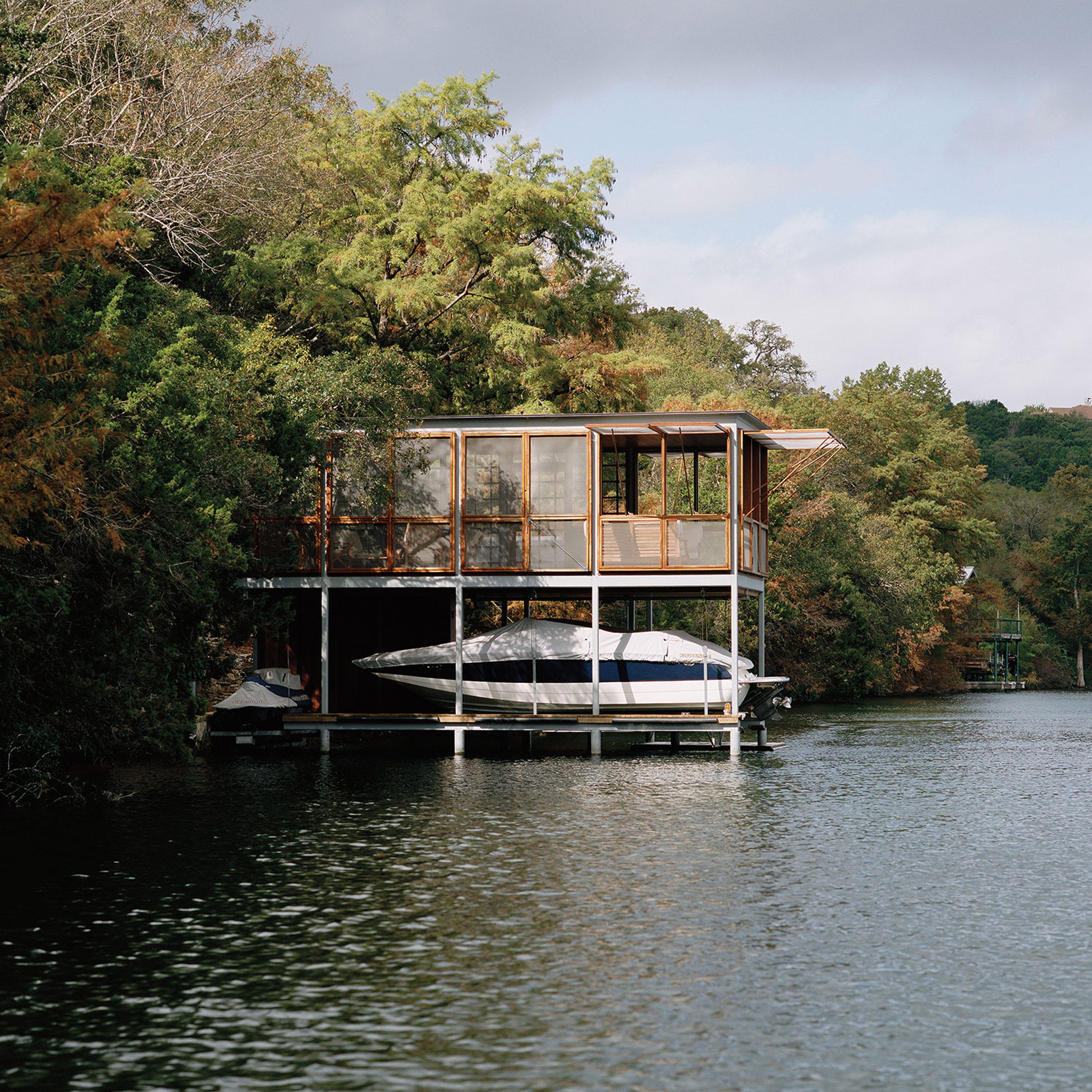 A two-storey boathouse jutting out onto a lake
