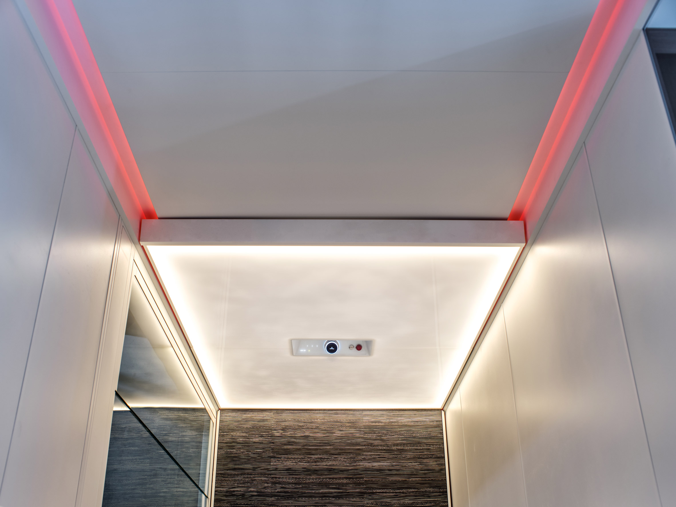 A photograph of red ceiling lights in a domestic elevator by Artico