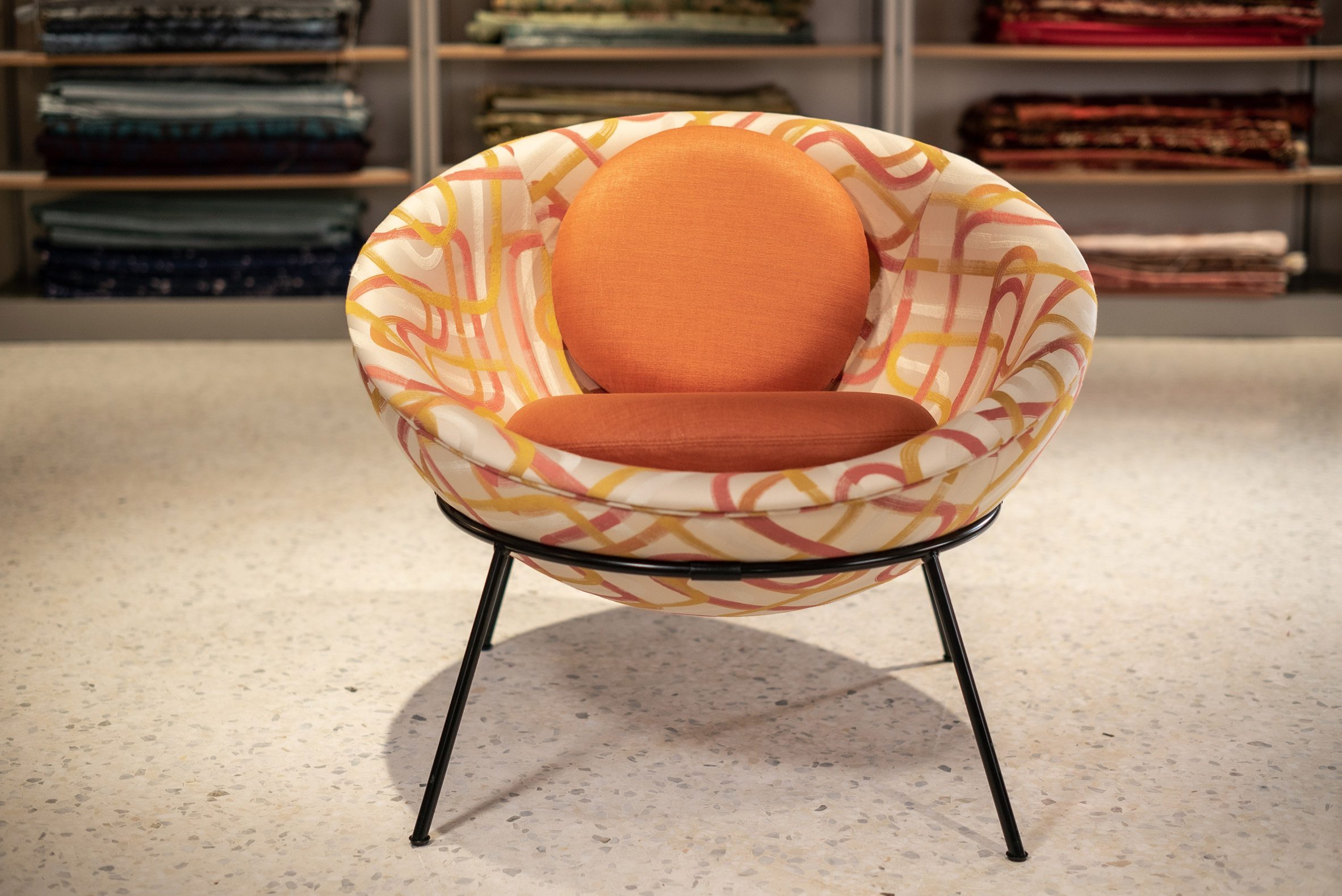 A photograph of the Bardi's Bowl Chair by Lina Bo Bardi for Arper in Lollipop fabric