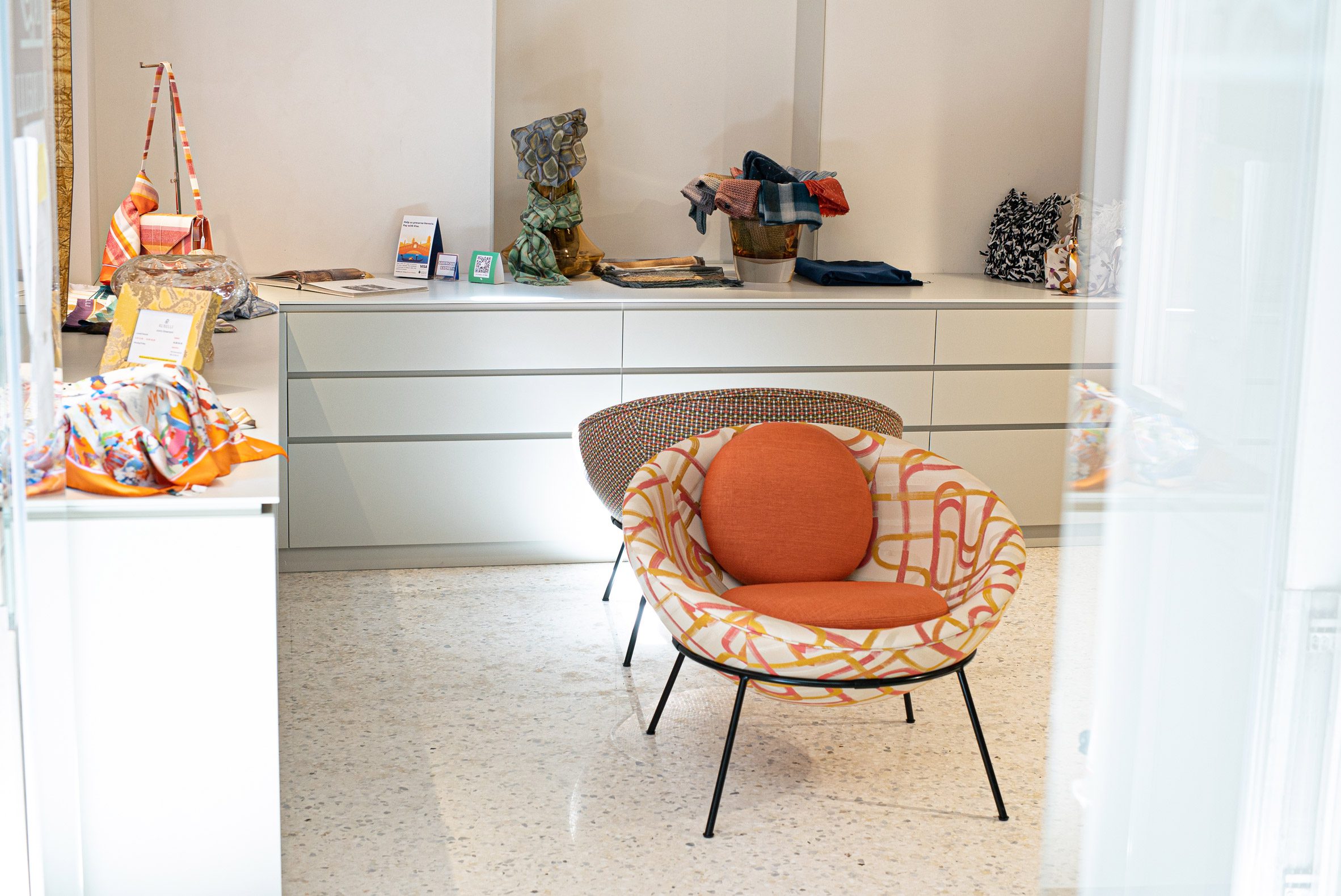 Orange Bardi's Bowl Chairs in a white interior with surrounding cabinetry and home accessories