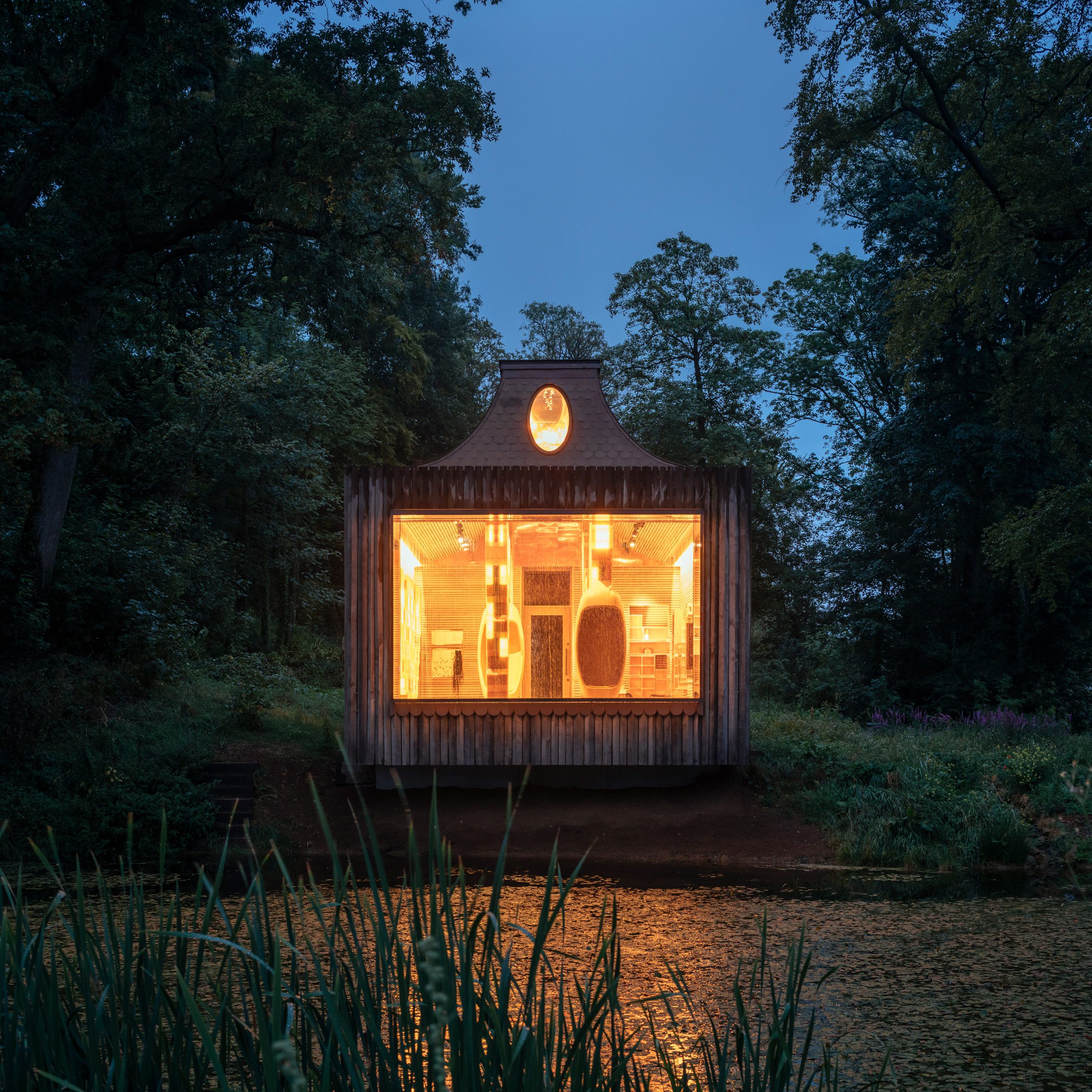 Night view across the lake for The Beezantium by Invisible Studio at The Newt in Somerset