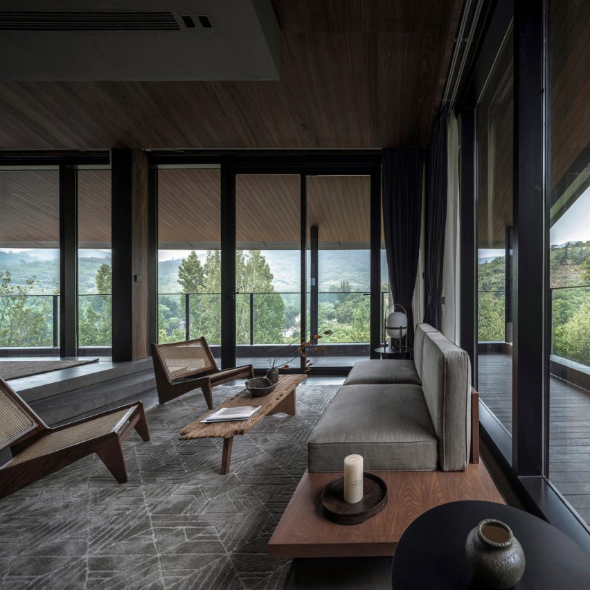 Seating area in front of panoramic windows in guest room of Cloud of Hometown Resort Hotel, China