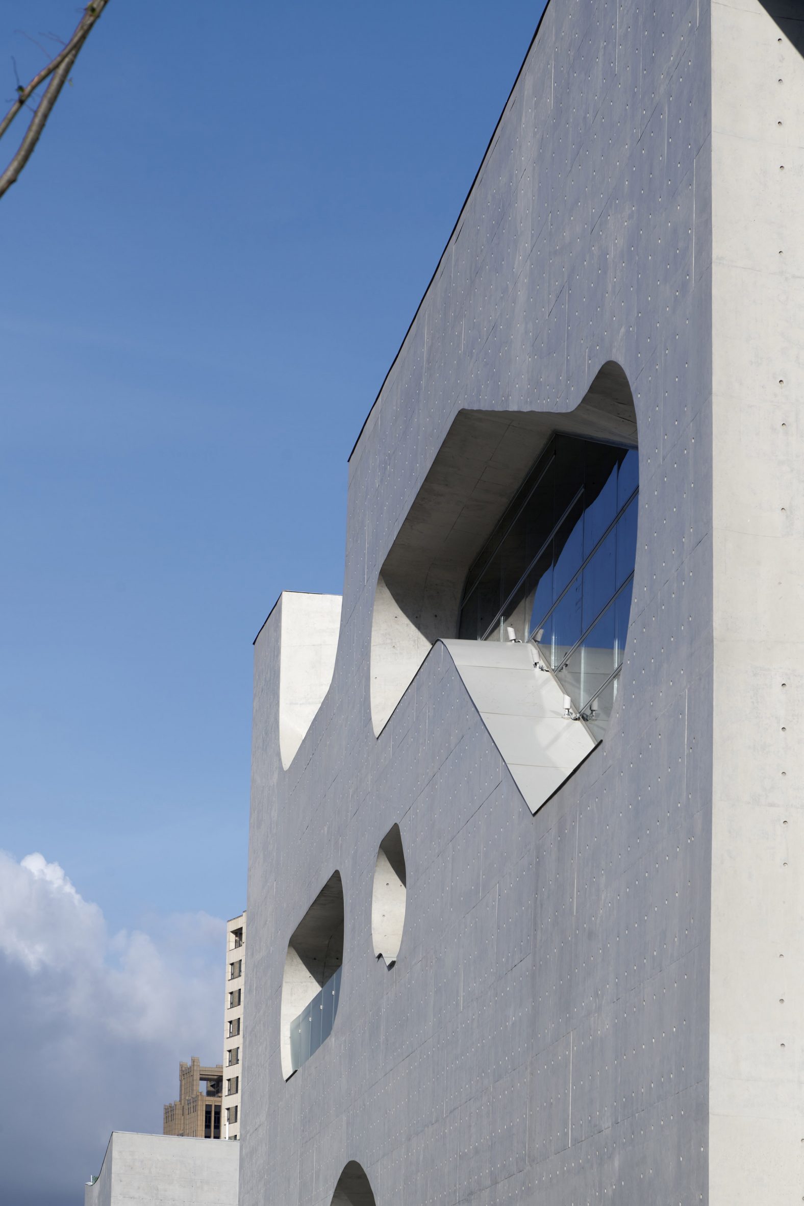 A grey building with irregular windows