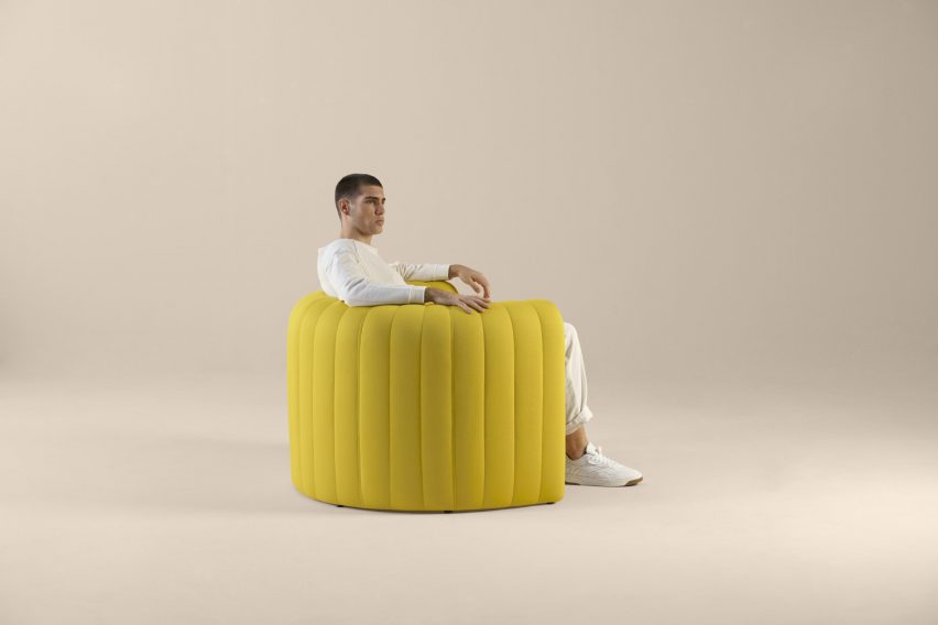 Man sitting on a mustard yellow Remnant armchair by Sancal