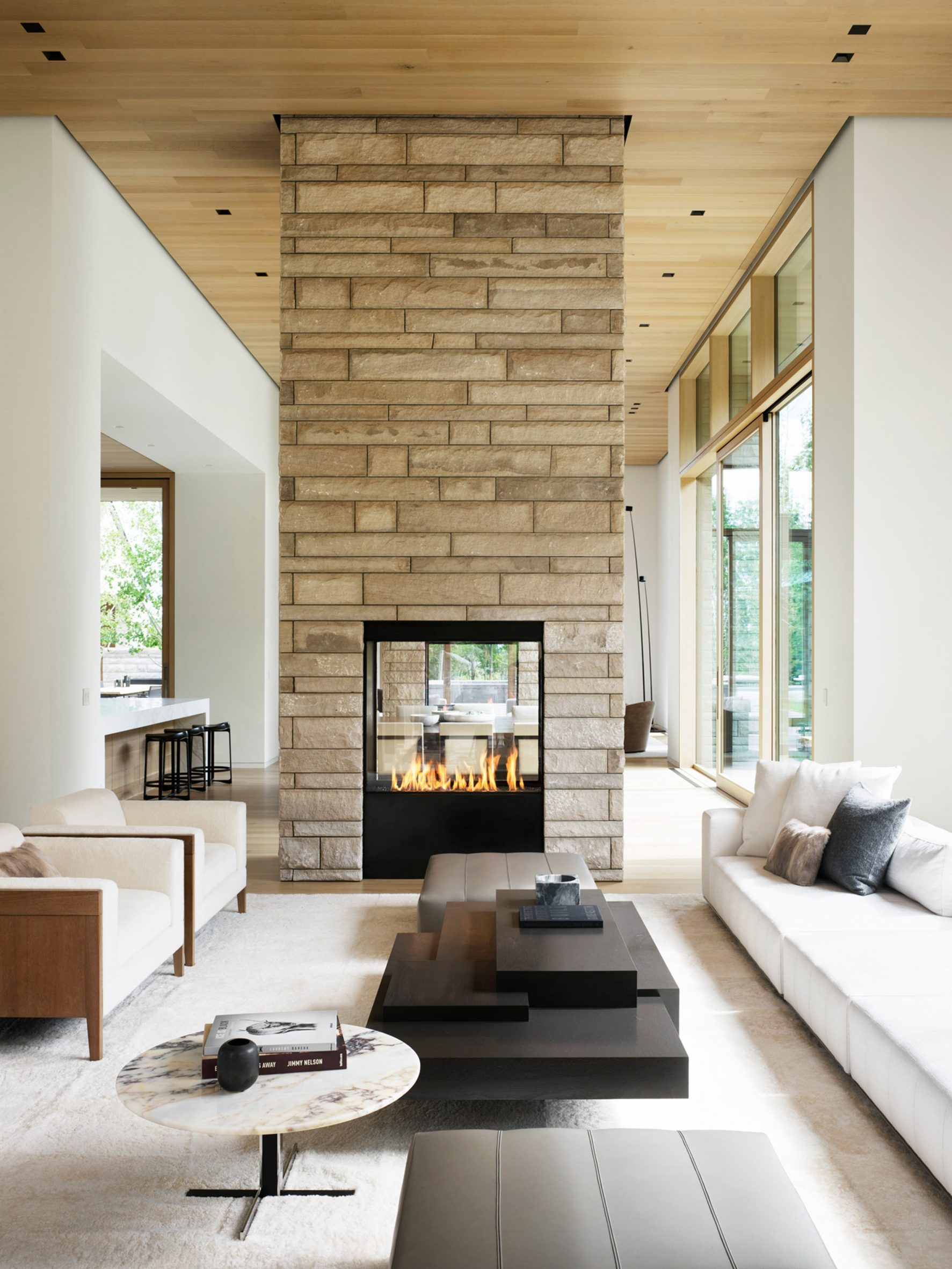 A stone wrapped chimney breast is located at the centre of a living room