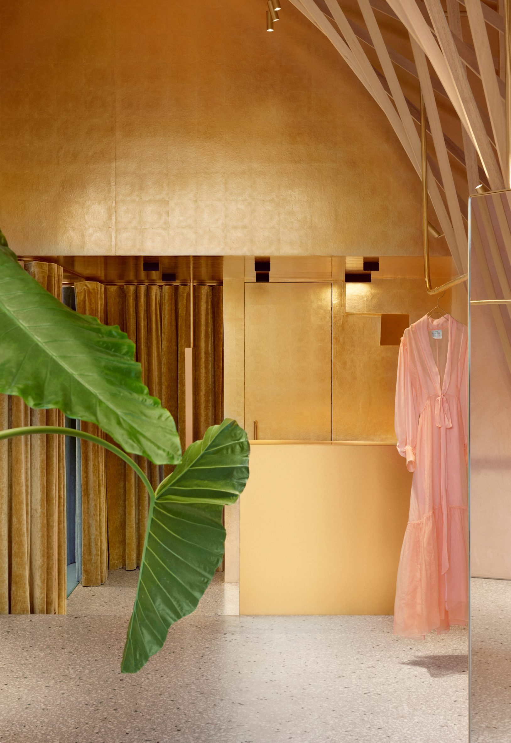 Gold-coloured walls and velvet curtains curtains in Forte dei Marmi retail space