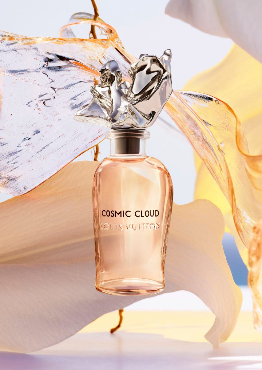 A Louis Vuitton perfume bottle with orange liquid inside