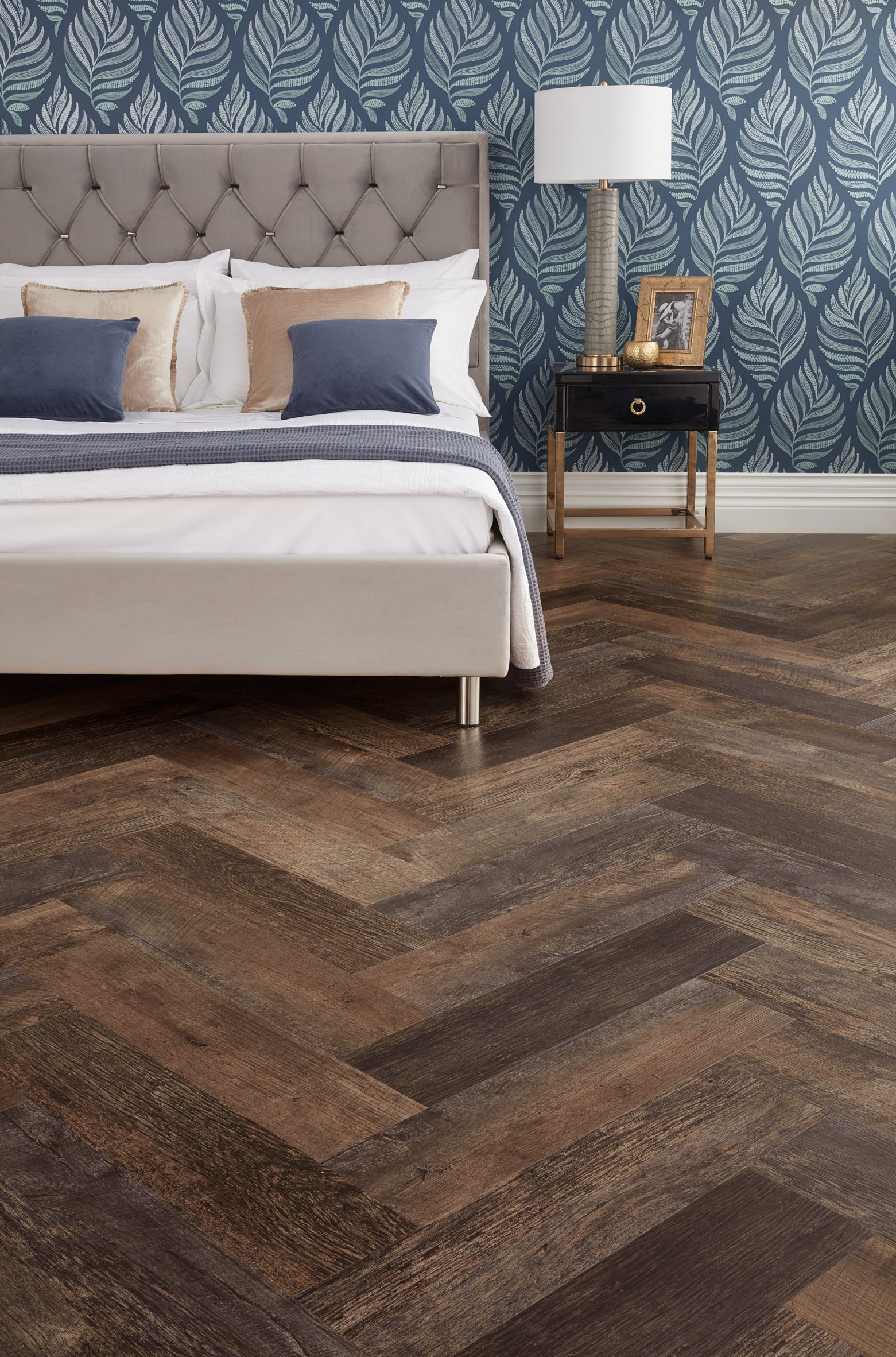 Dark herringbone flooring covers a bedroom