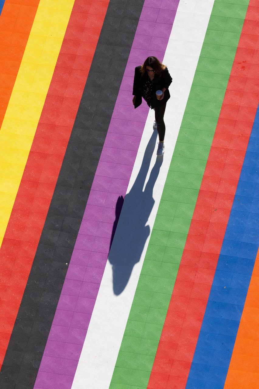 A person walks on multicoloured stripes