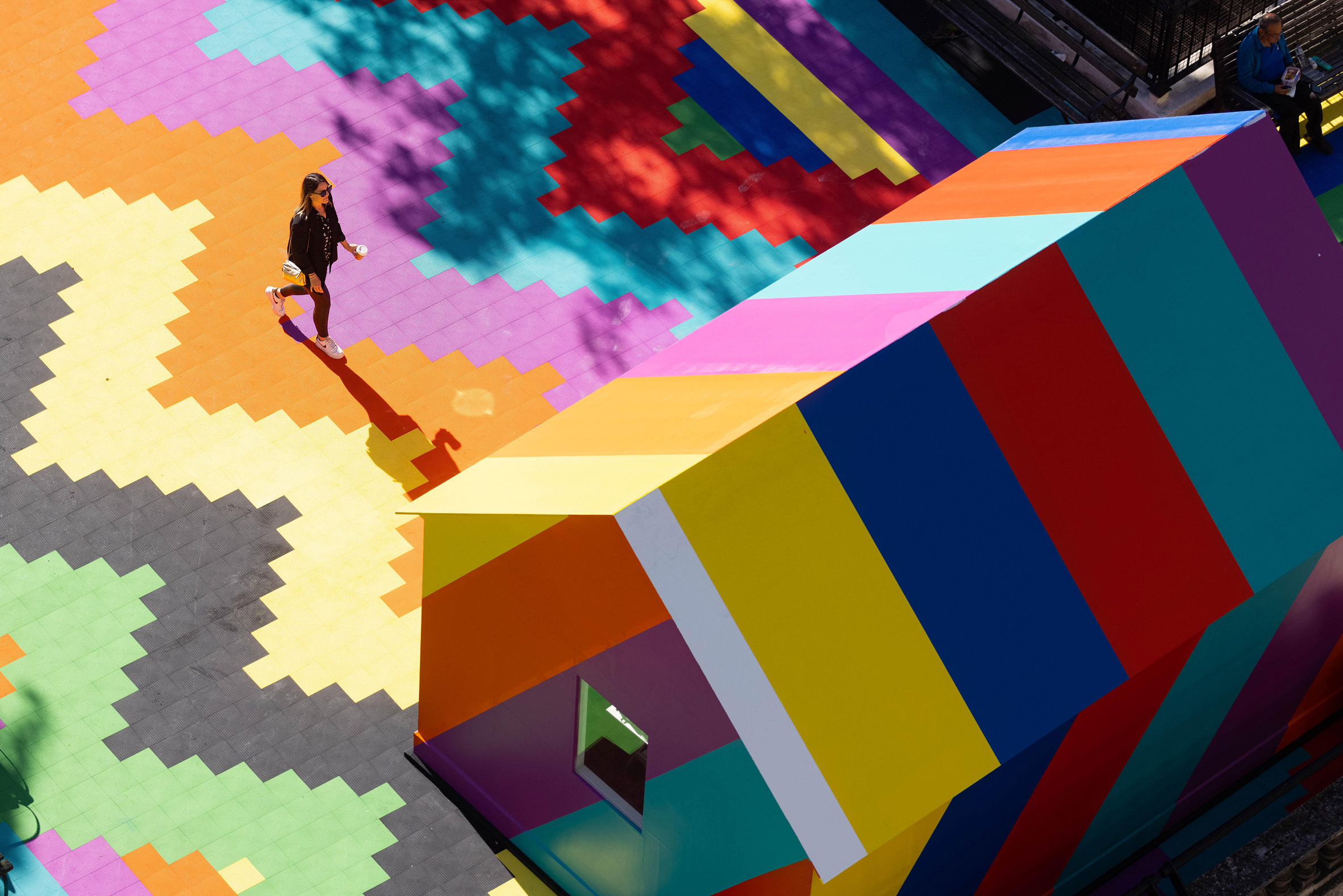 A woman walks across a brightly painted rooftop