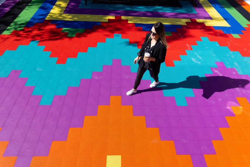 A woman walks across painted tiles